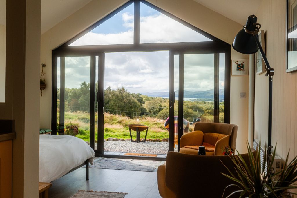 Morning light through cabin glass doors looking out over the fields to the bay